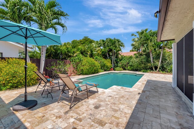 view of swimming pool featuring a sunroom and a patio