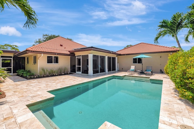 view of pool with a sunroom and a patio