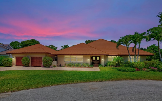 view of front of house with a garage and a yard