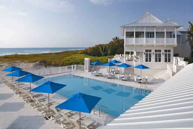 view of swimming pool featuring a water view and a patio area