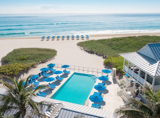 birds eye view of property featuring a water view and a beach view