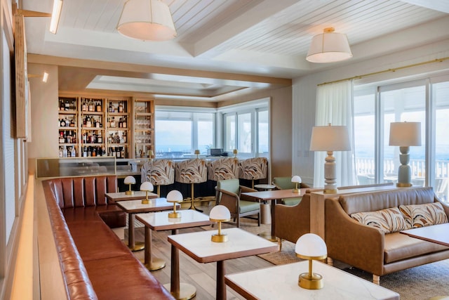 interior space featuring wooden ceiling, a wealth of natural light, indoor bar, and beamed ceiling