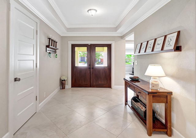 entrance foyer featuring a raised ceiling, light tile patterned floors, french doors, and crown molding