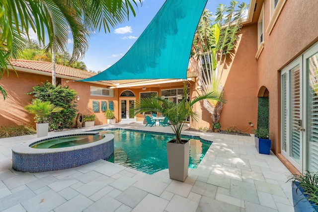 view of swimming pool featuring french doors, a patio area, and a pool with connected hot tub