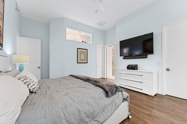 bedroom with ensuite bath, wood finished floors, and visible vents