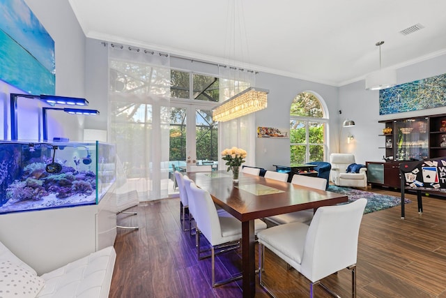 dining space with a chandelier, french doors, dark hardwood / wood-style floors, and crown molding