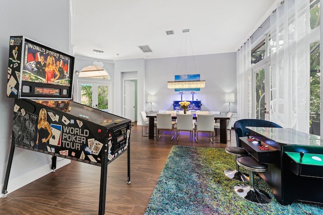 recreation room featuring crown molding, visible vents, wood finished floors, and french doors