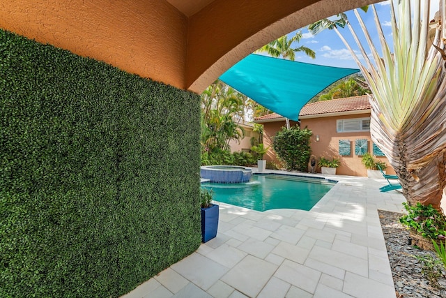 view of pool with a patio area and an in ground hot tub