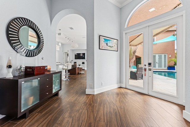 foyer entrance with french doors, dark hardwood / wood-style flooring, and crown molding