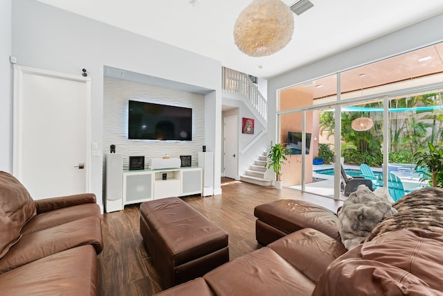 living area featuring stairs, visible vents, and wood finished floors