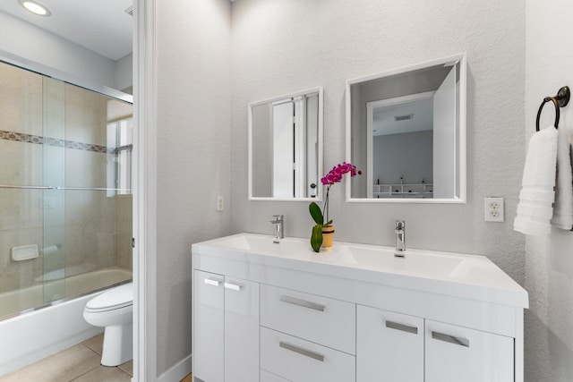 full bathroom with tile patterned flooring, vanity, toilet, and shower / bath combination with glass door