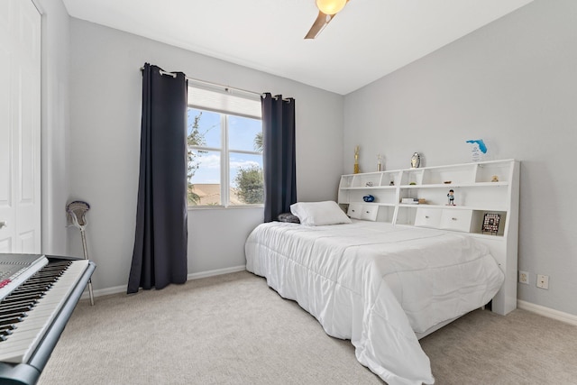 bedroom featuring light carpet, baseboards, and a ceiling fan