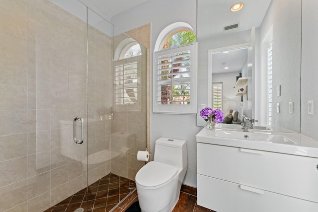 bathroom with toilet, recessed lighting, vanity, visible vents, and a stall shower