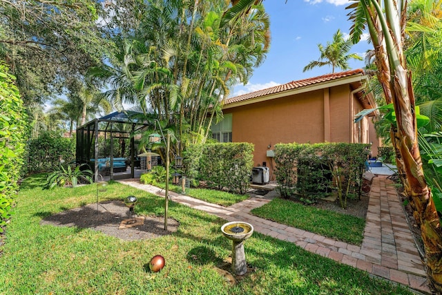 view of yard featuring glass enclosure and a patio area