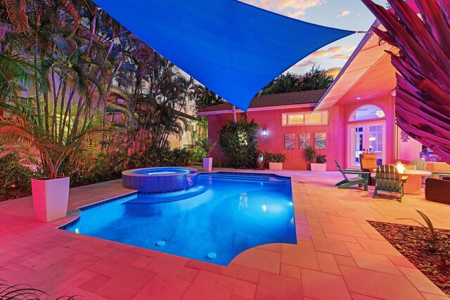 view of pool featuring a pool with connected hot tub, french doors, and a patio