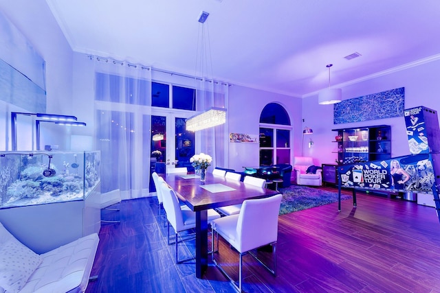 dining space featuring built in features, visible vents, crown molding, and wood finished floors