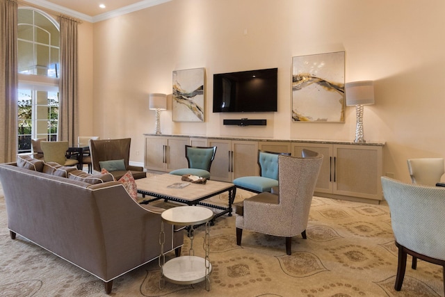 living area with a high ceiling, baseboards, and crown molding