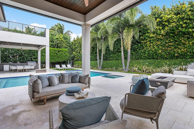 view of swimming pool featuring an outdoor living space, an outdoor kitchen, a patio, and ceiling fan