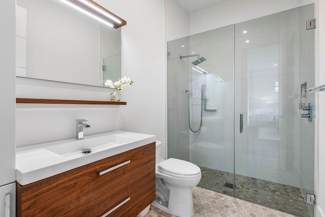 bathroom featuring tile patterned floors, vanity, toilet, and a shower with shower door