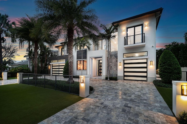 modern home with a yard, a balcony, and a garage