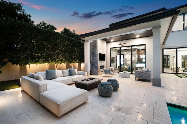 view of patio with ceiling fan and an outdoor living space with a fire pit