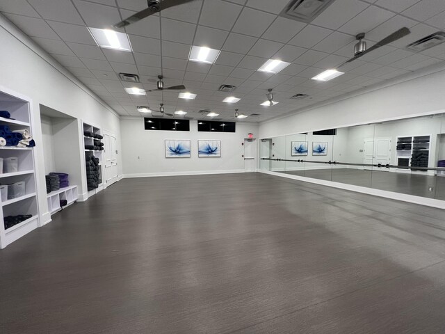 interior space with a paneled ceiling and built in shelves