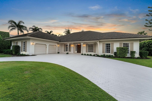 ranch-style home with a garage and a yard