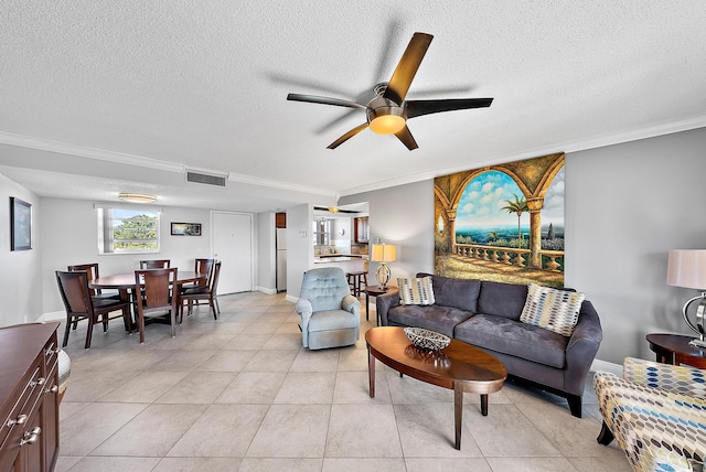 living room with ceiling fan, light tile patterned floors, crown molding, and a textured ceiling