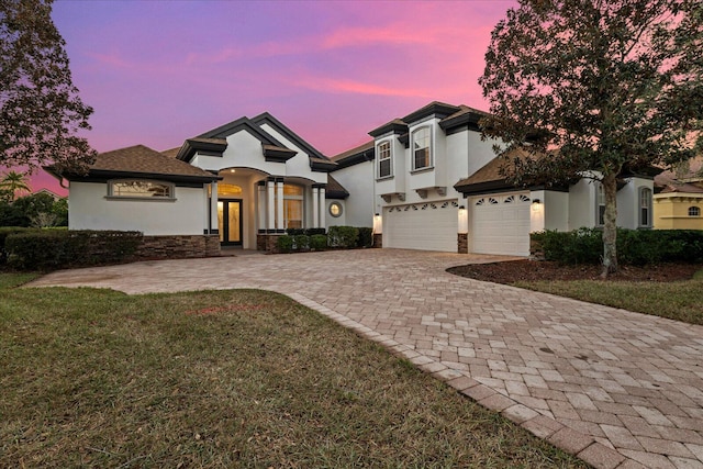 view of front of house with a garage and a yard