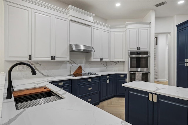 kitchen featuring white cabinets, blue cabinetry, and range hood