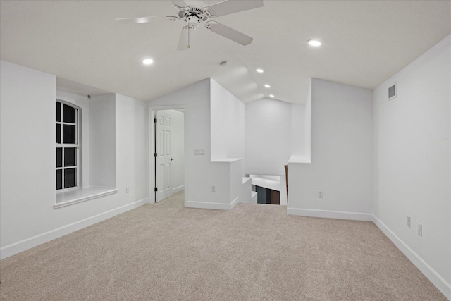 interior space featuring light carpet, vaulted ceiling, and ceiling fan