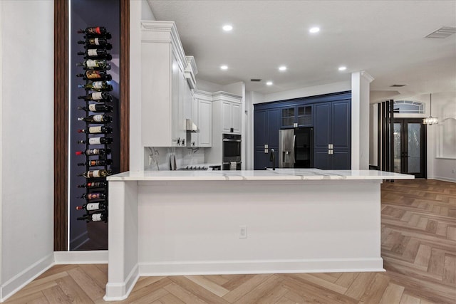 kitchen with kitchen peninsula, blue cabinetry, appliances with stainless steel finishes, and light parquet flooring