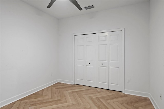 unfurnished bedroom with ceiling fan, a closet, and light parquet flooring