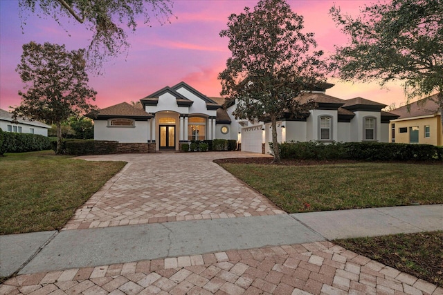 mediterranean / spanish home with a garage and a yard