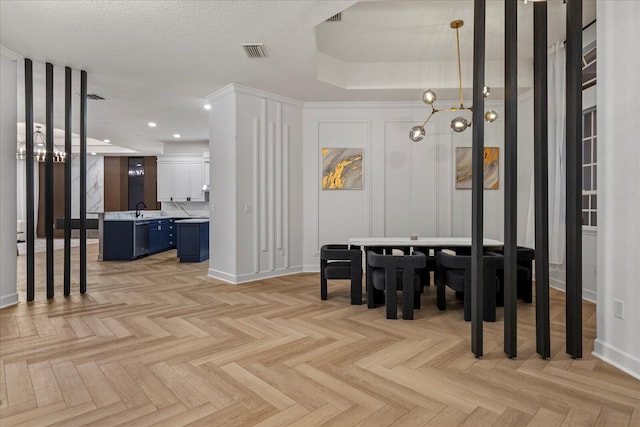 interior space with light parquet flooring, an inviting chandelier, and sink