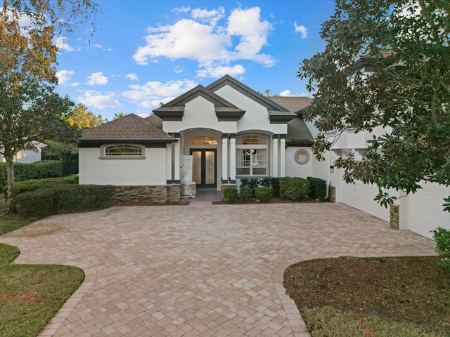 view of front of home with covered porch, french doors, and a garage