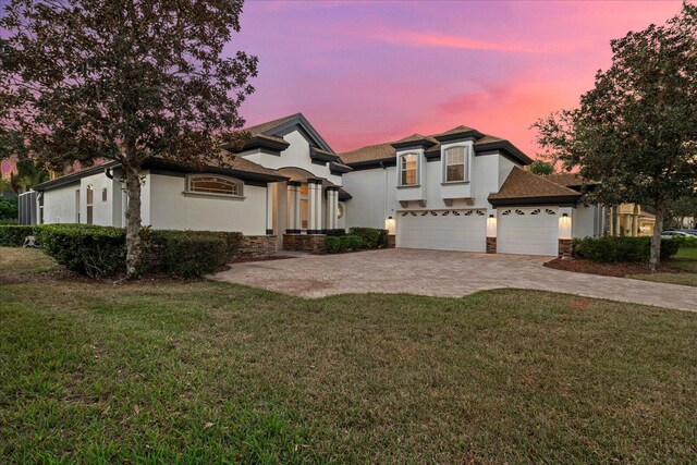 view of front of home featuring a garage and a lawn