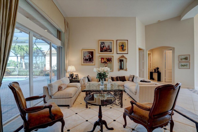 living room with light tile patterned floors and high vaulted ceiling