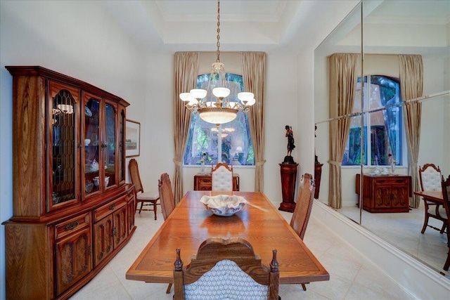 dining area with a tray ceiling, ornamental molding, and an inviting chandelier