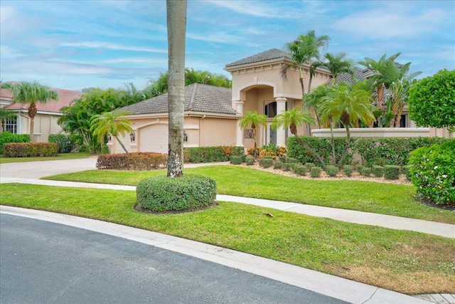 mediterranean / spanish home with a front yard and a garage