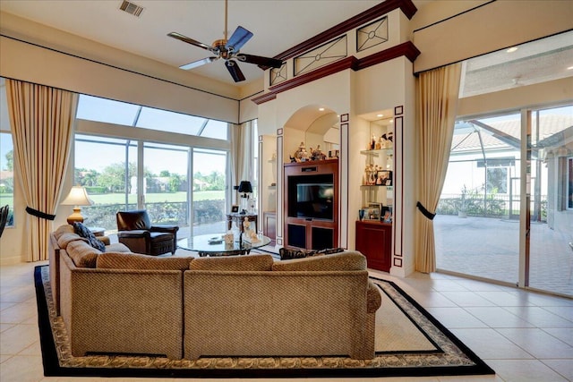 living room featuring a wealth of natural light, light tile patterned flooring, a high ceiling, and ceiling fan