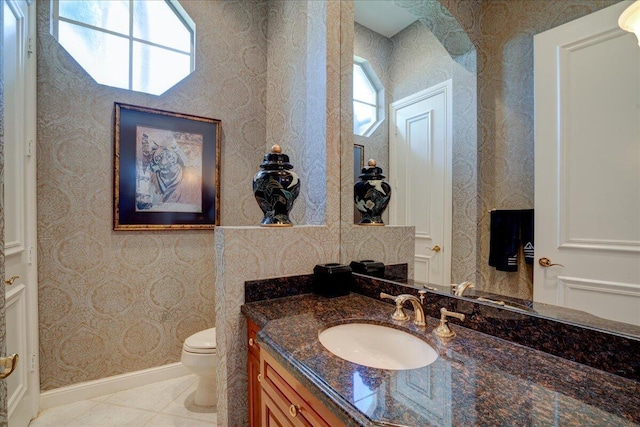 bathroom with tile patterned floors, a wealth of natural light, vanity, and toilet