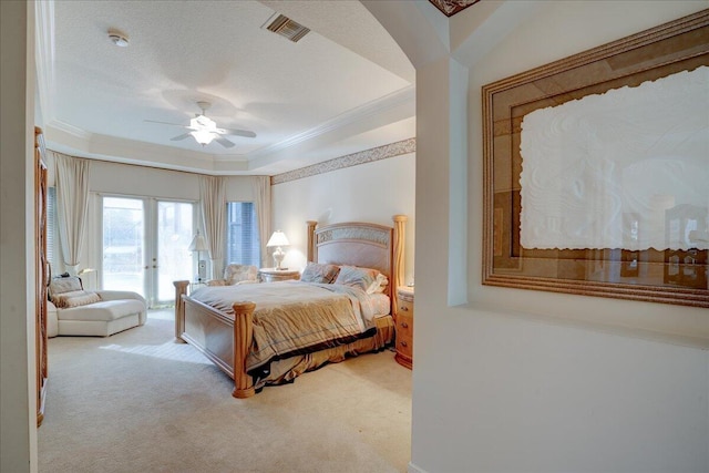 carpeted bedroom featuring a raised ceiling, ceiling fan, and ornamental molding