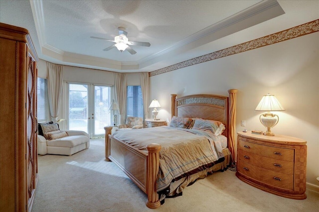 bedroom with a raised ceiling, ceiling fan, light colored carpet, and access to outside