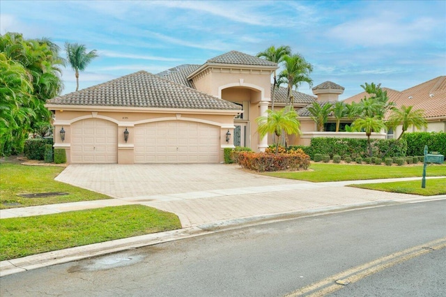 mediterranean / spanish house with a garage and a front yard