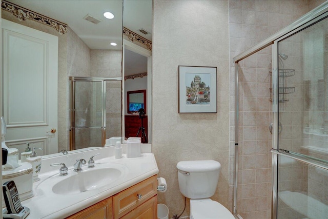 bathroom with vanity, toilet, and a shower with shower door