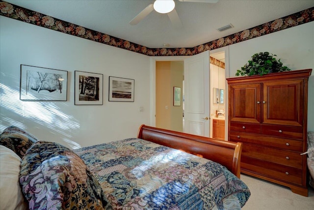 carpeted bedroom featuring ceiling fan and ensuite bathroom