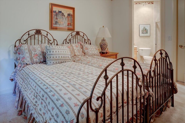 bedroom featuring ensuite bathroom and light colored carpet