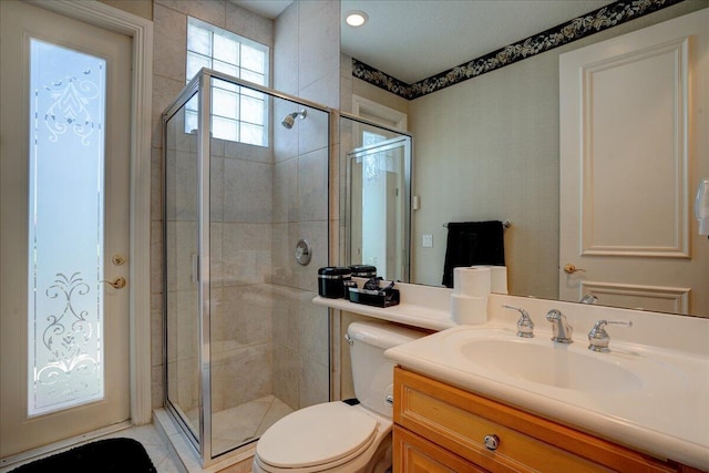 bathroom featuring vanity, toilet, and an enclosed shower