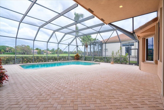 view of swimming pool with glass enclosure and a patio area